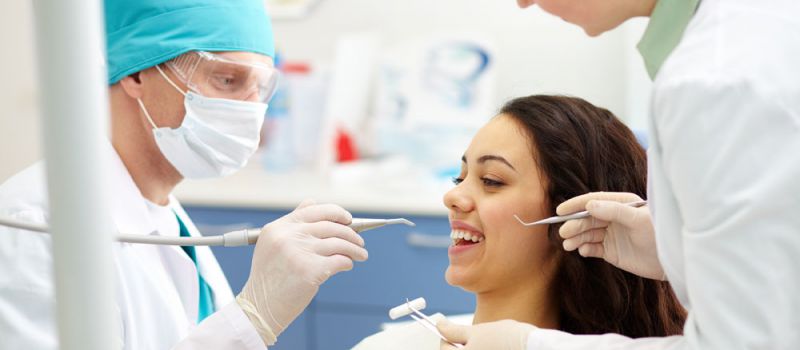 A dentist examining a patient's teeth.